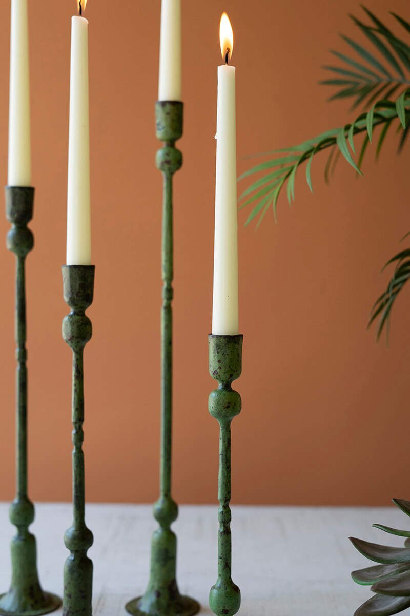 close-up of Green candle holders with lit candles against a brown background