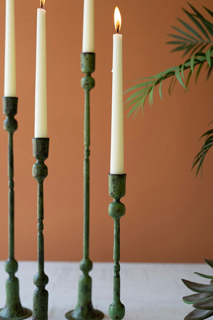 close-up of Green candle holders with lit candles against a brown background