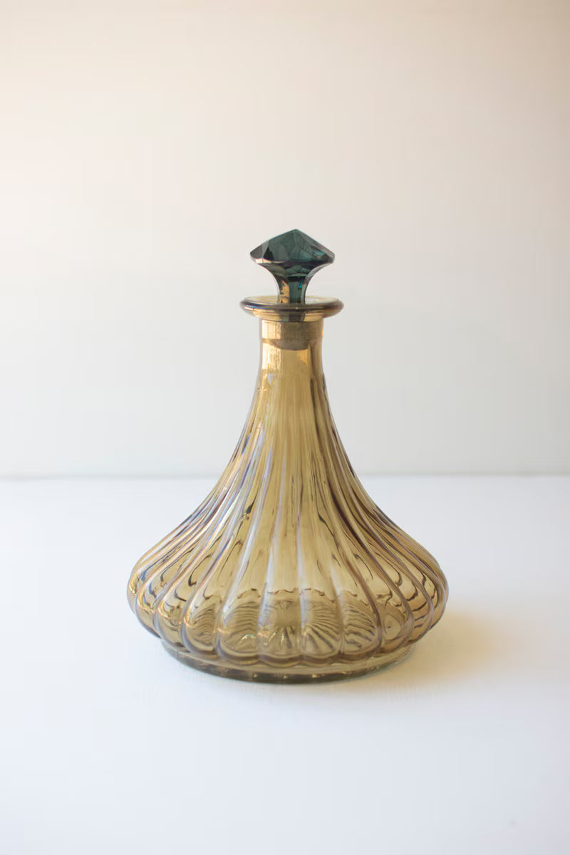 olive colored glass decanter with teal stopper shown on a white background