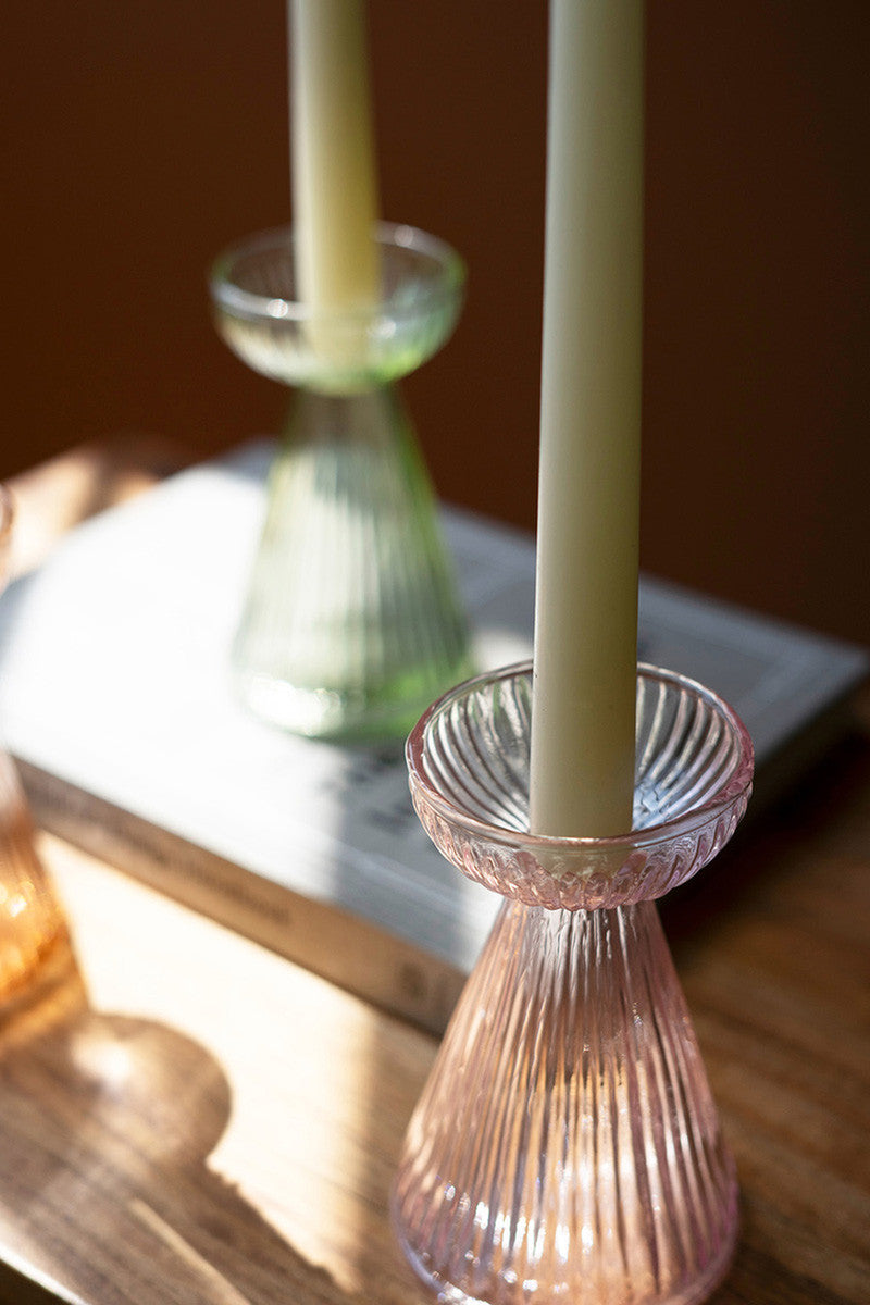 close-up of lilac vase with a taper candle in it.
