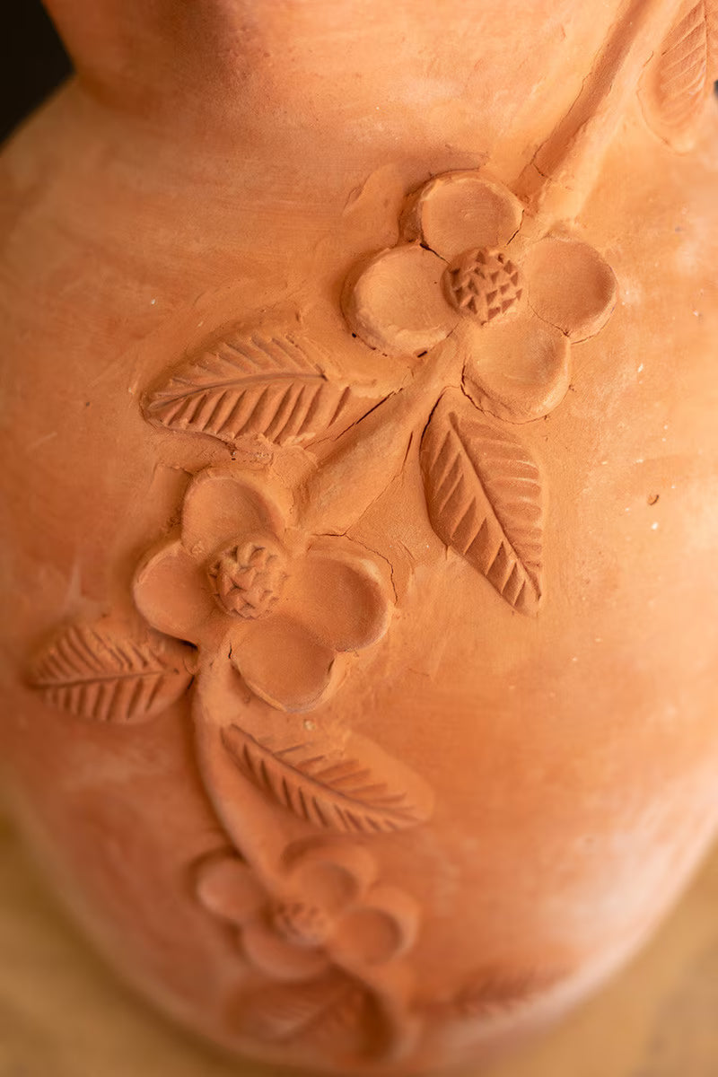Close-up of a terracotta pot with floral embossing