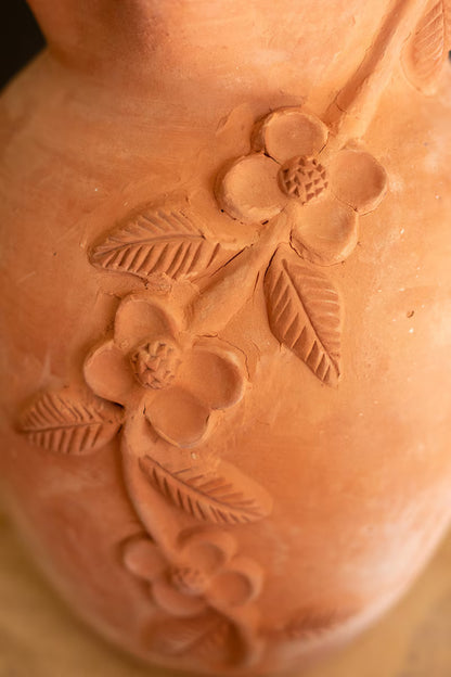 Close-up of a terracotta pot with floral embossing