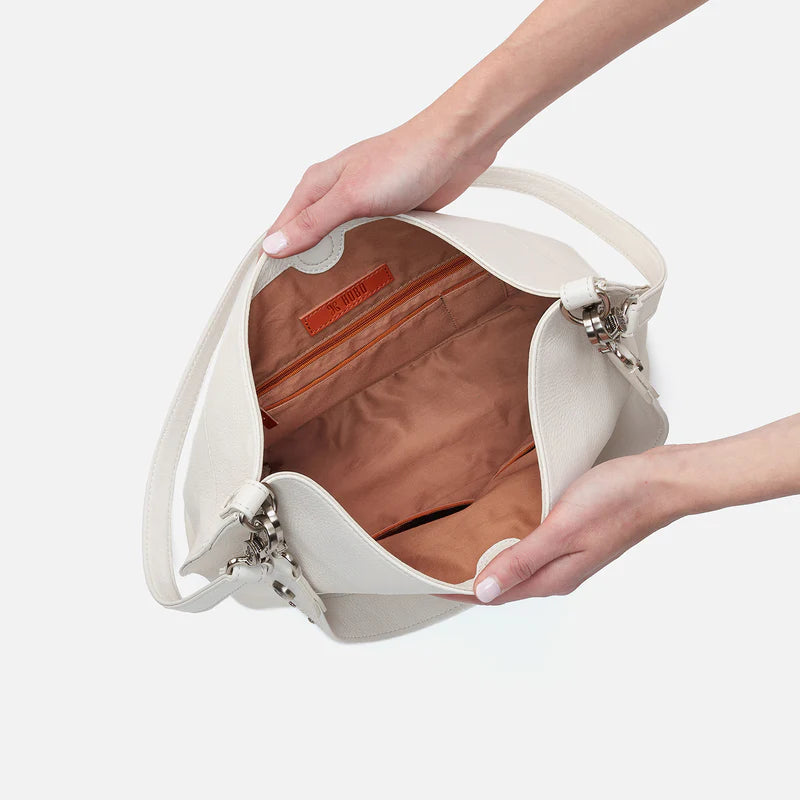 hands holding open white pier bag showing interior.