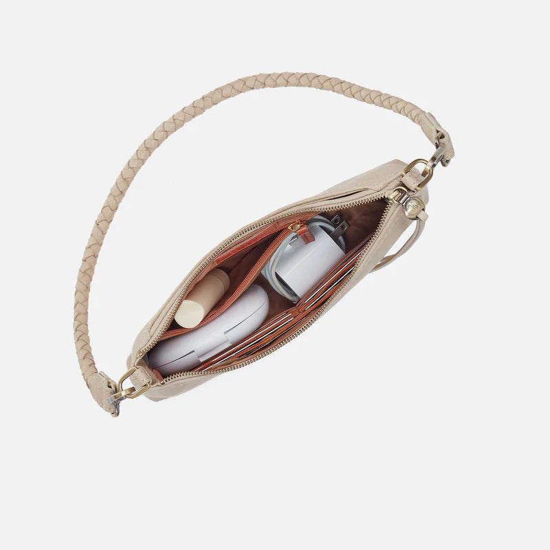 top down open view with items inside of the Darcy crossbody with braided strap in the taupe color called frosted pearl