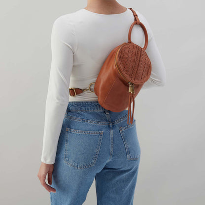 person wearing jeans and a white top with harvest wheat Sheila Sling Bag over their shoulder