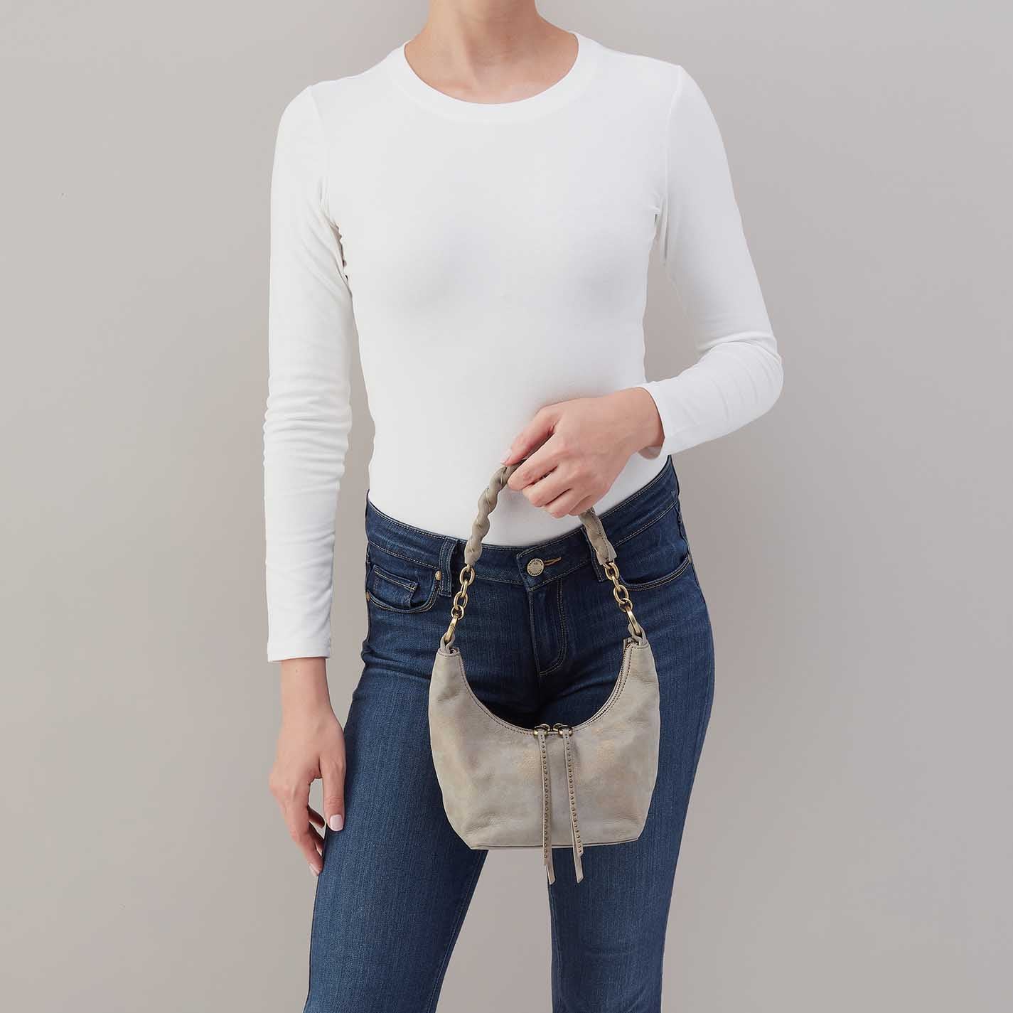 person wearing jeans and a white top holding golden granite Astrid Small Crossbody