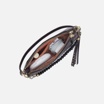 top down open view of items inside the Darcy crossbody with beaded handle in the dark grey/black color called flintrock