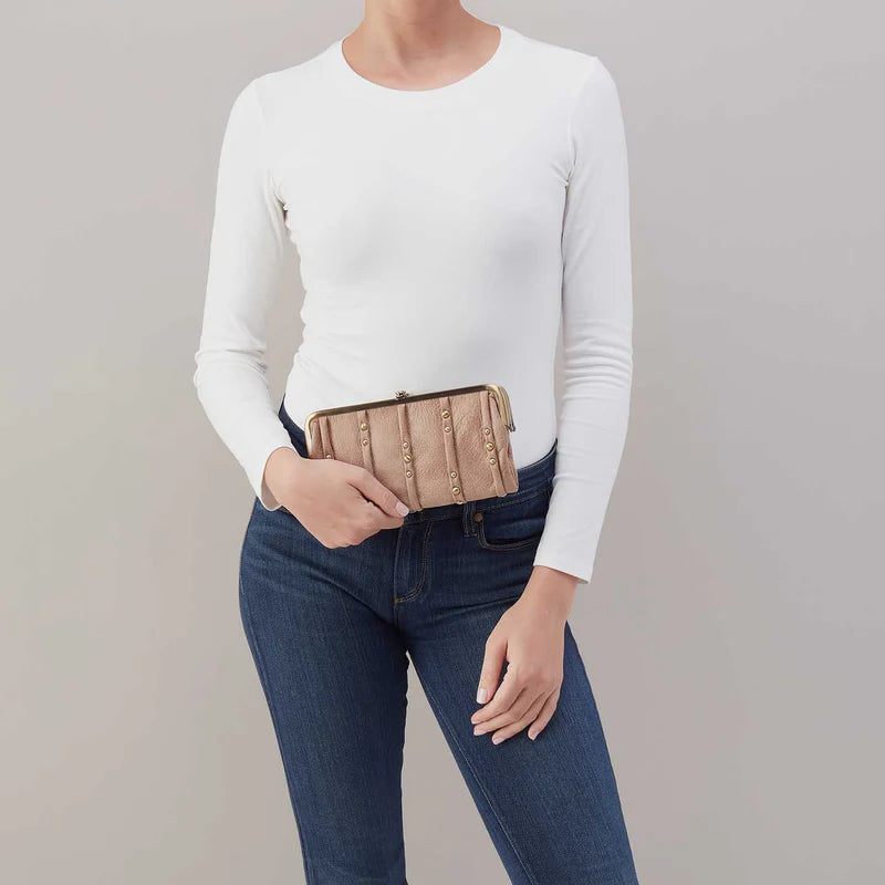 person wearing jeans and a white top holding hazel Lauren Clutch Wallet