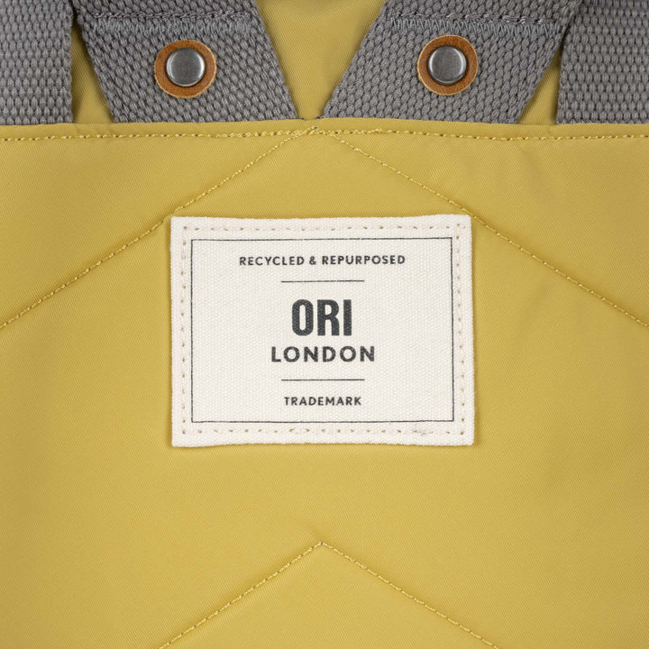 close of yellow canfield b backpack's ori logo tag.