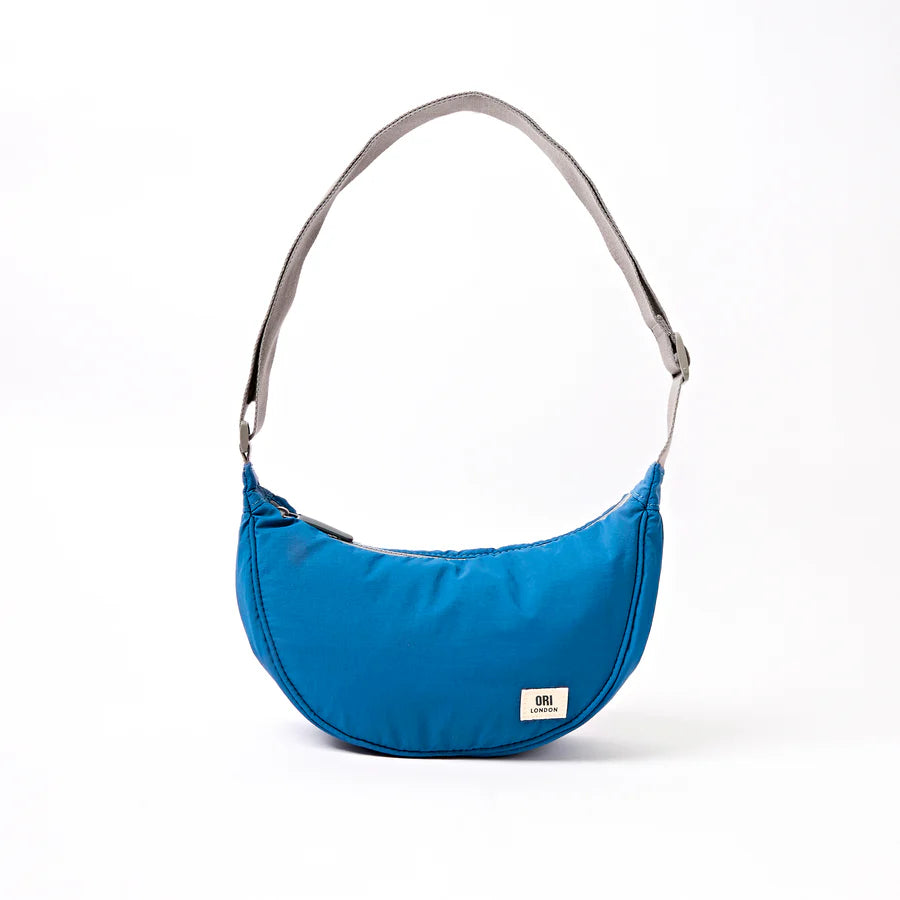 bright Blue shoulder bag with a light grey strap on a white background