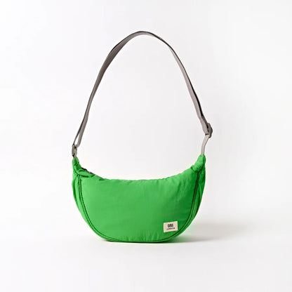 bright green crescent shaped shoulder bag with light grey handle shown on a white background