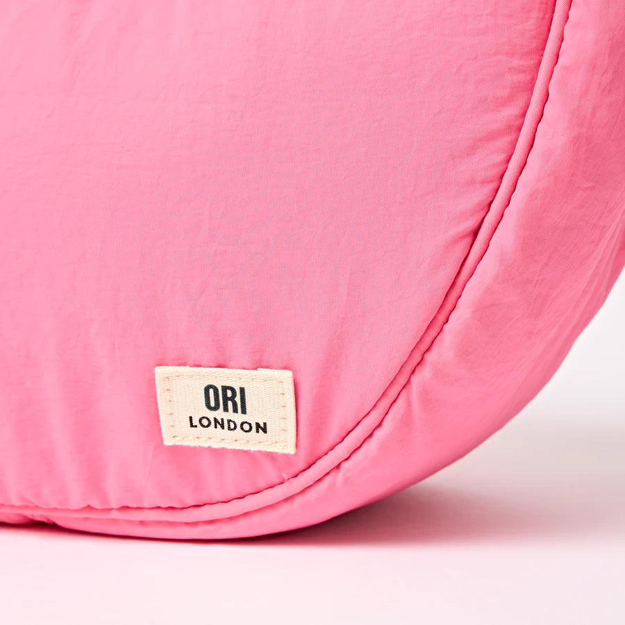 close-up of bottom corner of pink bag with ori london label