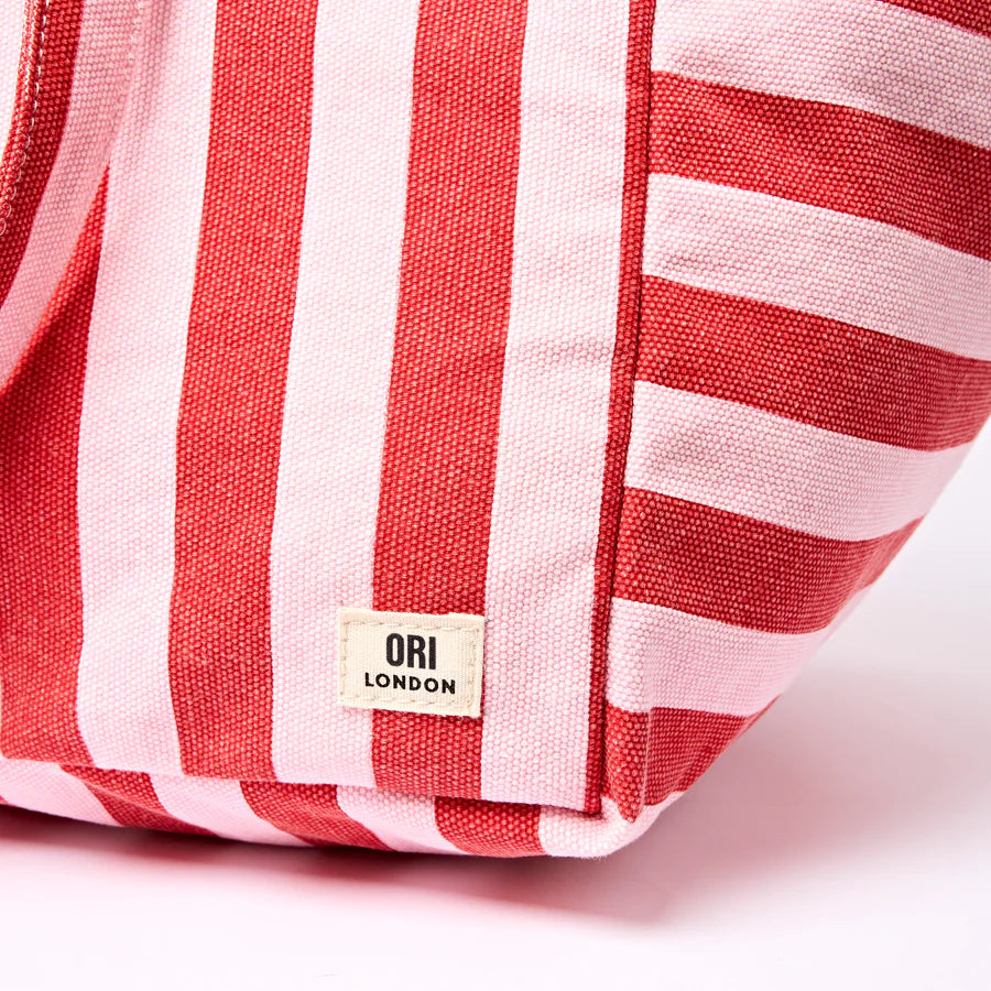 Red and pink striped bag with 'Ori London' label on a light pink background