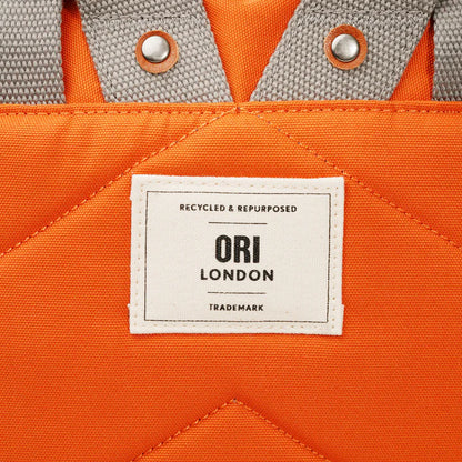 Close up of Ori London patch on back of backpack.