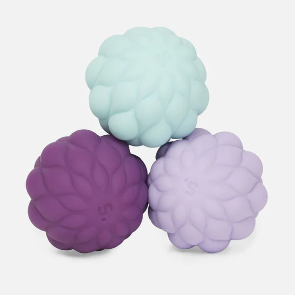 puffs spek silicone balls in purple and teal hues stacked on top of each other