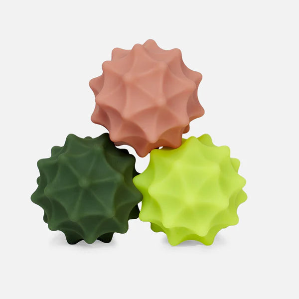 spur spek silicone balls in green and coral colors stacked on top of each other