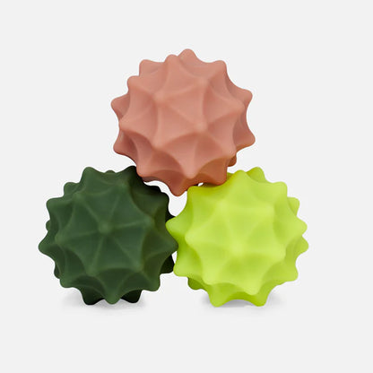 spur spek silicone balls in green and coral colors stacked on top of each other