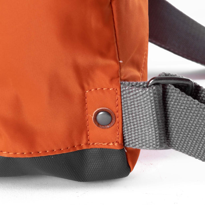 close of orange bantry b backpack's strap attachments.