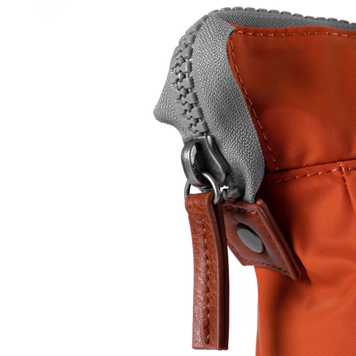 close of orange bantry b backpack's zipper pull.