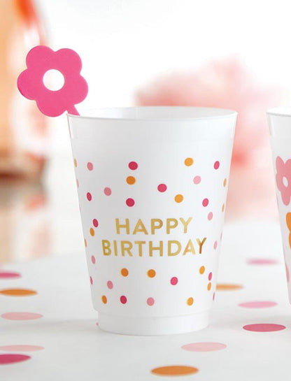 cup printed with happy birthday with a pink flower stir stick in it.