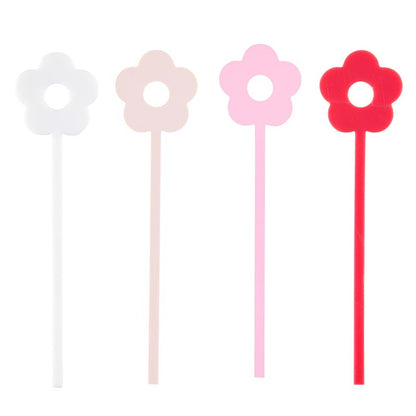 4 stir sticks in shades of pink in a row on a white background.