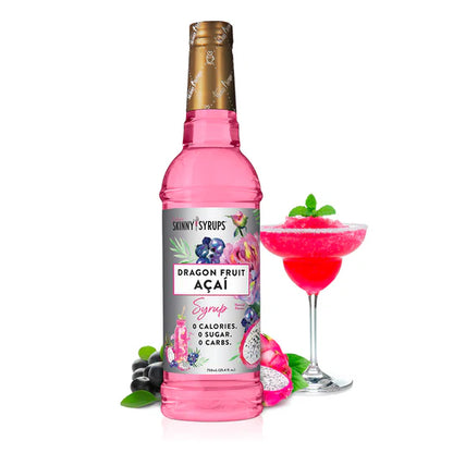 bottle of dragon fruit acai skinny syrup set next toa margarita glass filled with red beverage and a sprig of mint.