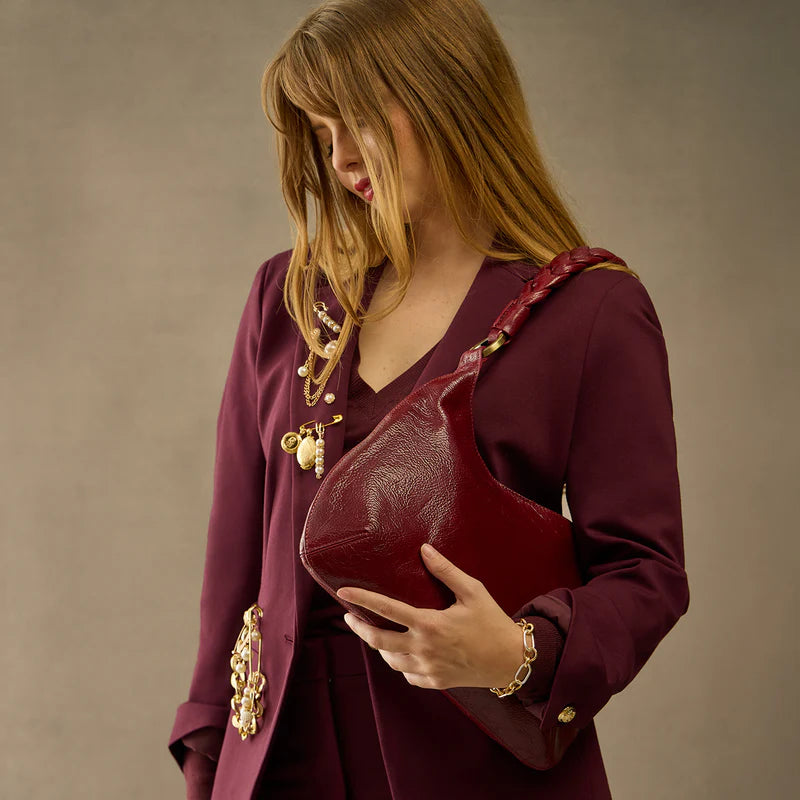 person wearing maroon pant suit with garnet gloss Madison Shoulder Bag on their shoulder