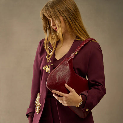person wearing maroon pant suit with garnet gloss Madison Shoulder Bag on their shoulder