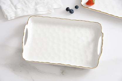 White ceramic tray with gold rim on a marble surface