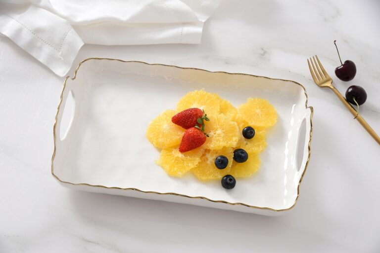 fruit dessert on a white tray with strawberries and blueberries, set against a white background.