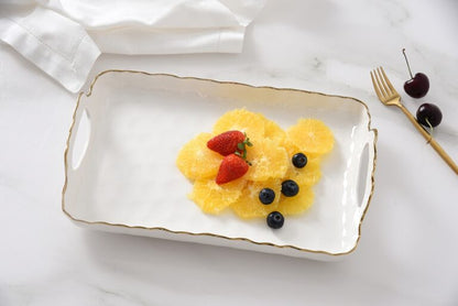 fruit dessert on a white tray with strawberries and blueberries, set against a white background.
