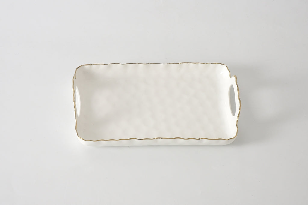 Rectangular ceramic tray with gold rim on a light gray background