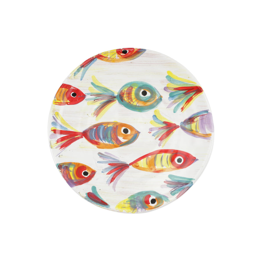 top view of white salad plate with colorful fish painted on it.