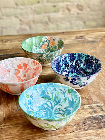 side view of 4 assorted colorful bowls arranged on a table.