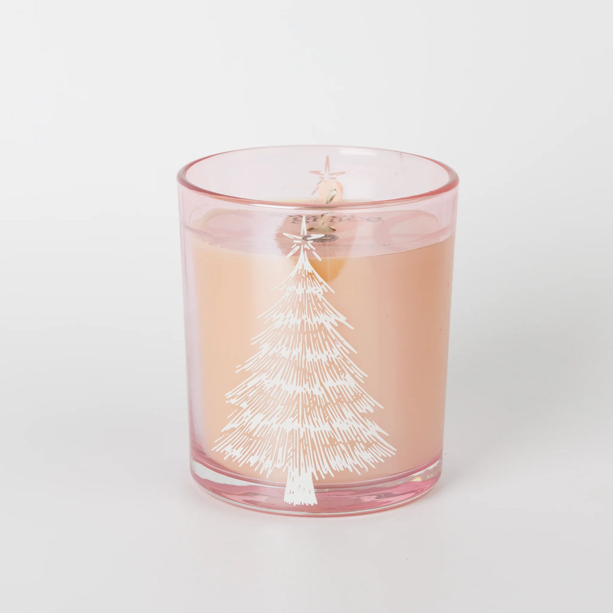 A pink-tinted glass candle jar with a white printed Christmas tree design, filled with pale peach wax and topped with a wick and small star detail, shown on a clean white background.