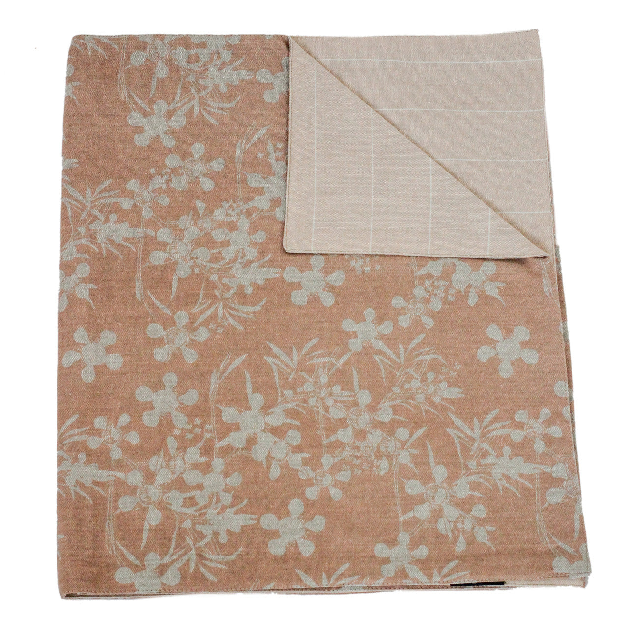 blush terracotta runner with botanical design folded with one corner flapped over showing the reverse side.