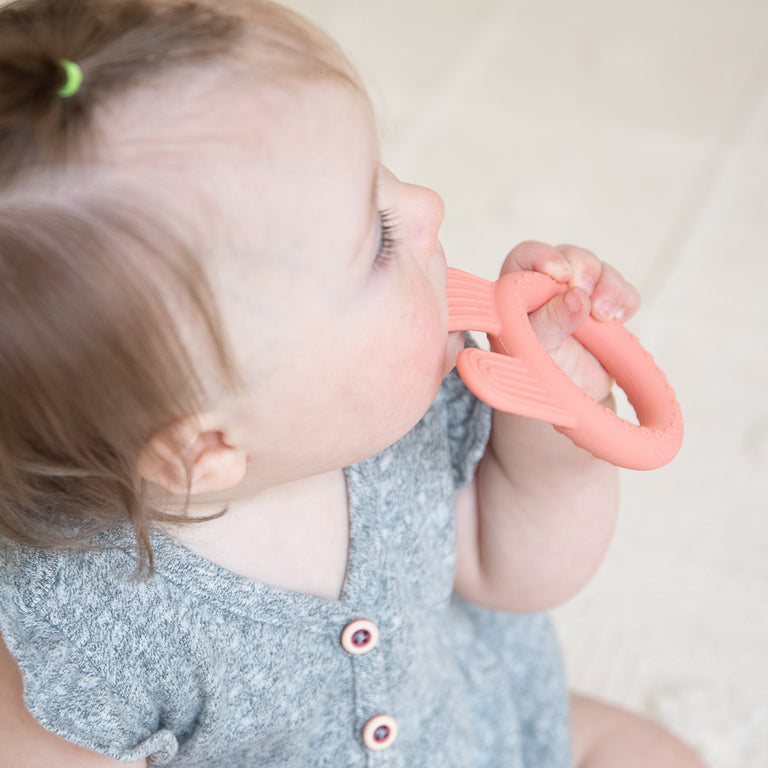 baby chewing on bunny teether.