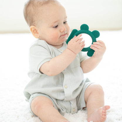 baby looking at frog teether.