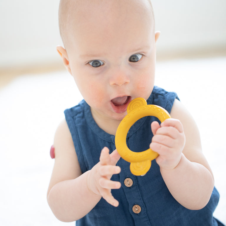 baby playing with monkey teether.
