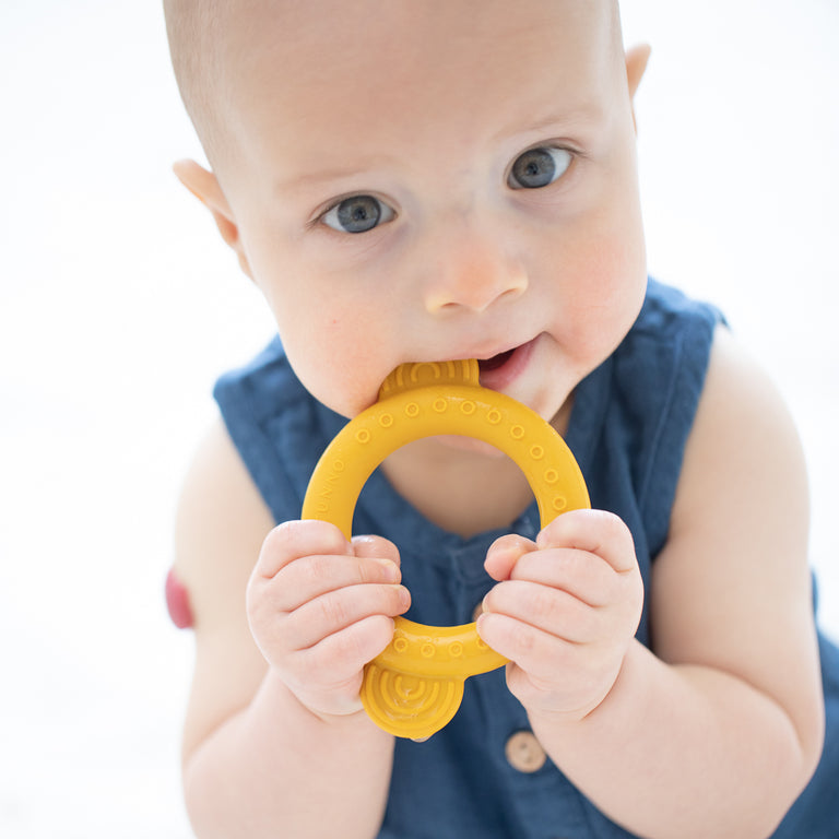 baby chewing on monkey teether.