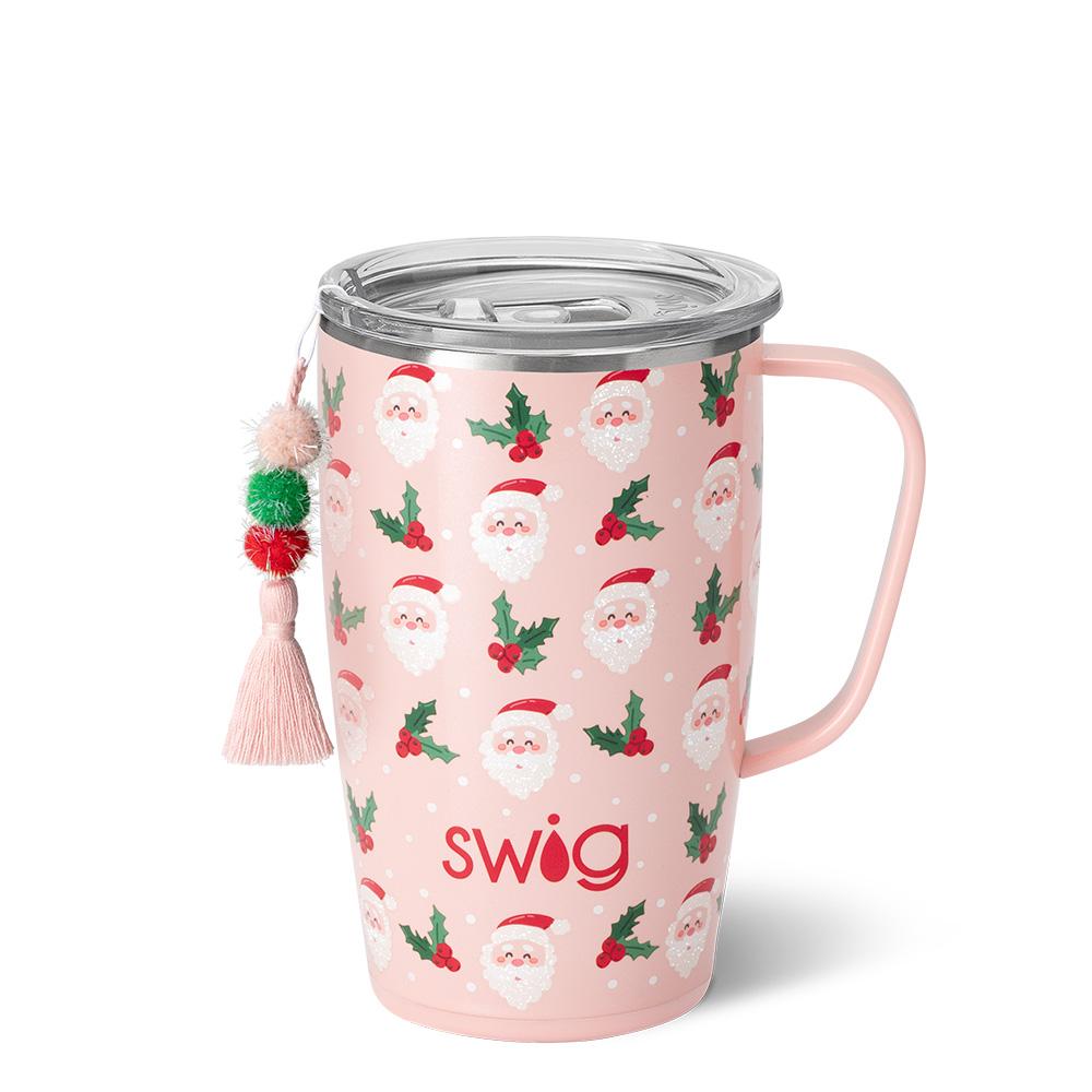 pink travel mug with all-over pattern of Santa faces and sprigs of holly, a pink tassel hangs from the mug.