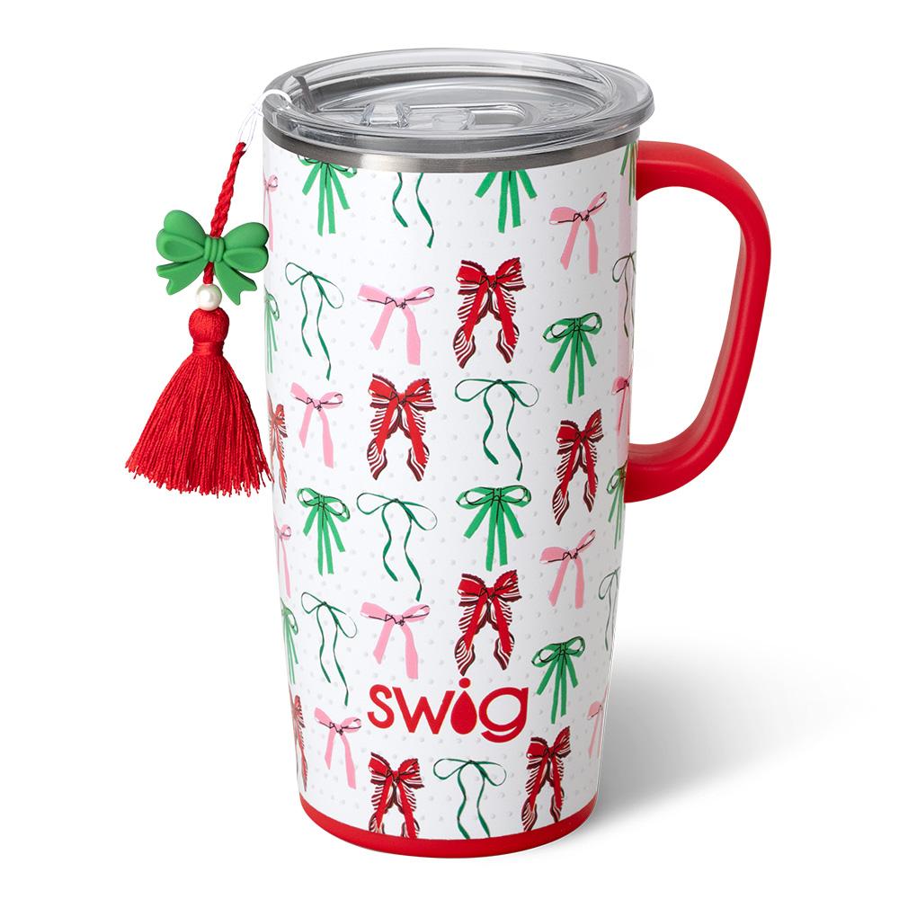 white tumbler with all-over bow design, red handle and red tassel hanging off it.