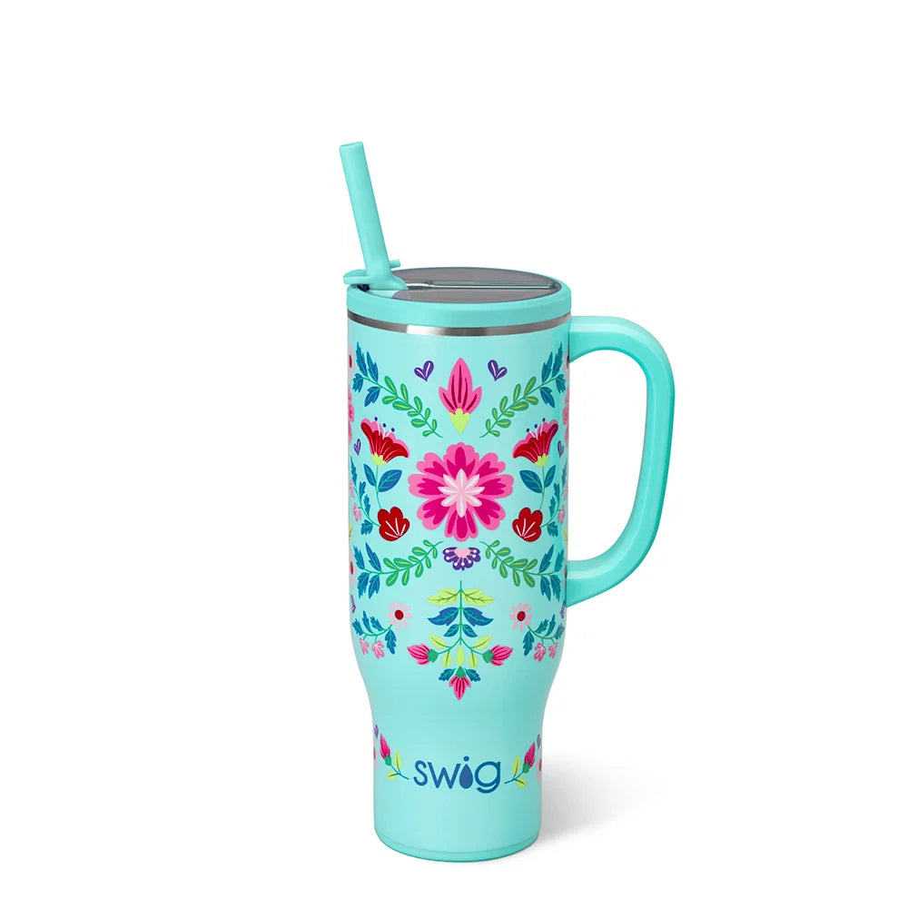 Turquoise tumbler with floral design, handle, and straw on a white background