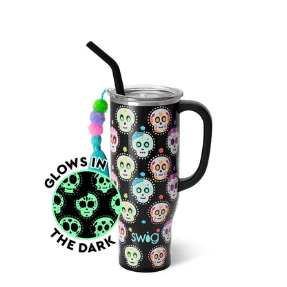 black tumbler with sugar skull and flower pattern in bright pink, blue, orange, and yellow and an inset showing glow in the dark pattern.