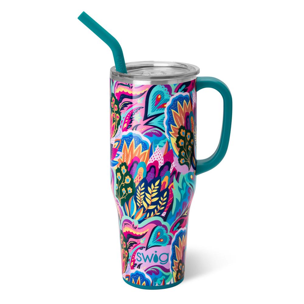 brightly colored mug with floral pattern and teal handle and straw on a white background.