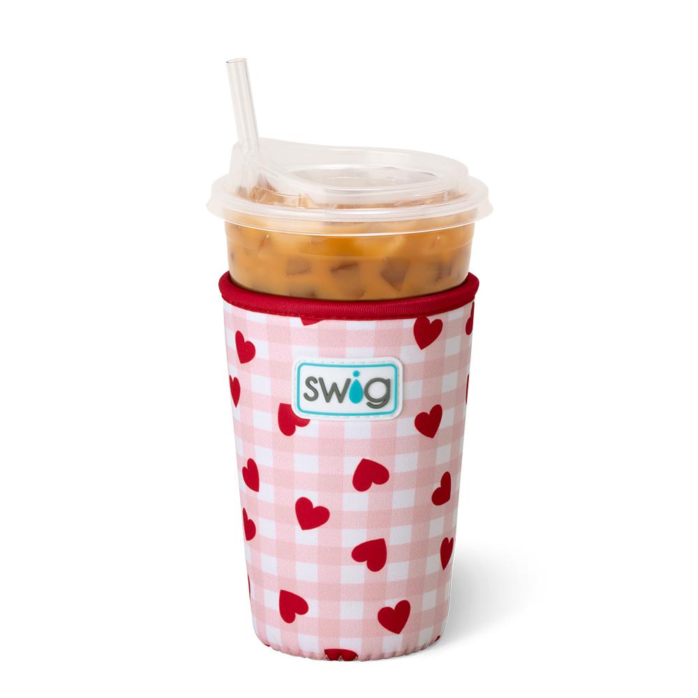 pink and white check coolie with red hearts on it on an iced beverage.