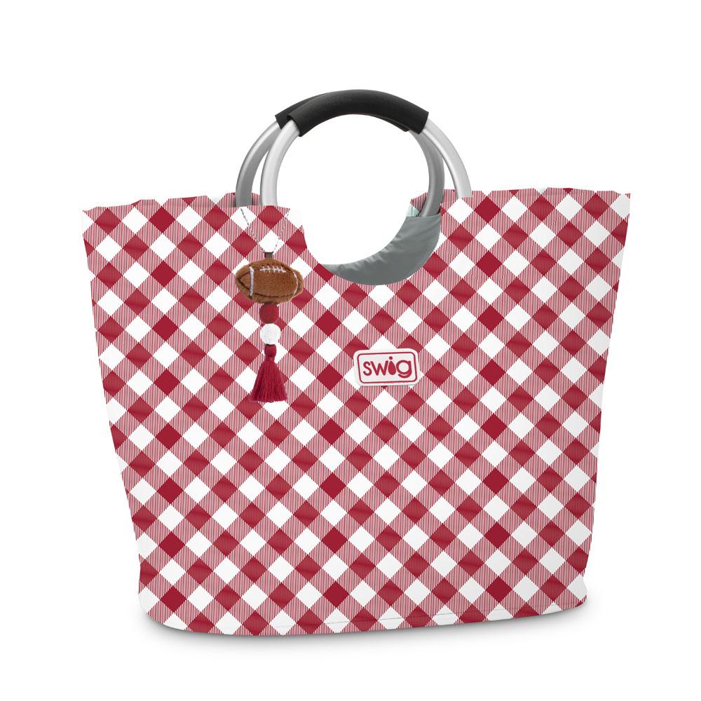A red and white gingham tote bag with a black and silver ring handles, featuring a football-shaped charm and an 'swig' logo patch.