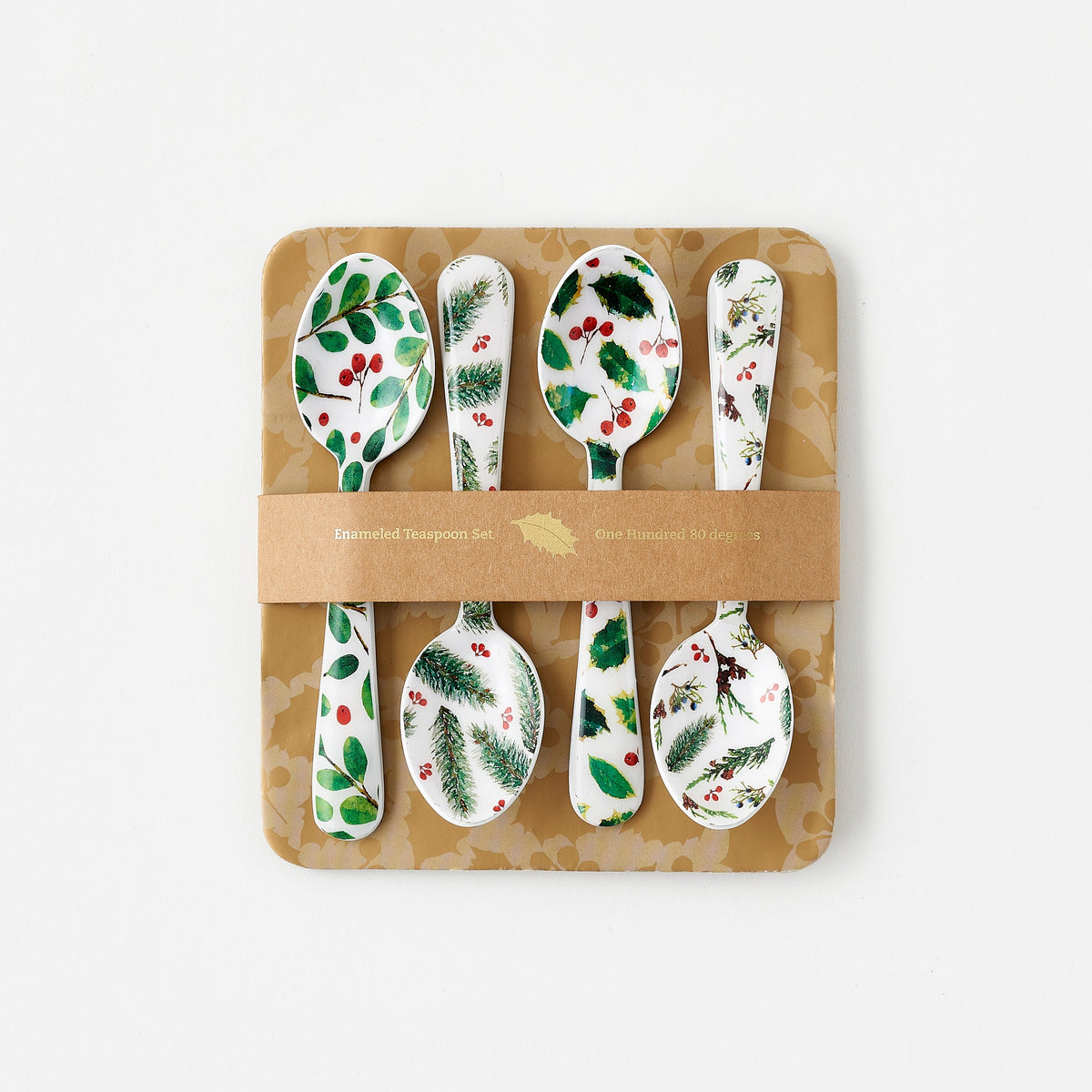 4 assorted winter botanical spoons with evergreen designs on a cardboard backer board