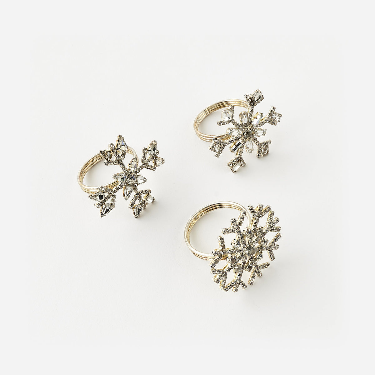 3 snowflake napkin rings on a white background