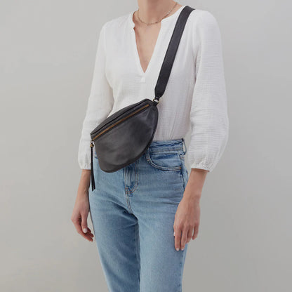 person wearing jeans and a white top with black Juno Belt Bag over their shoulder